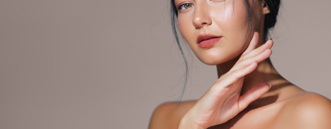 A woman examining smooth, refreshed skin in a mirror at a med spa in Jericho, Long Island, after a Botox treatment
