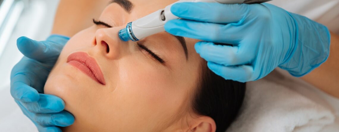 A woman relaxing during a HydraFacial treatment at a med spa in Jericho, Long Island, with the device being applied to her face