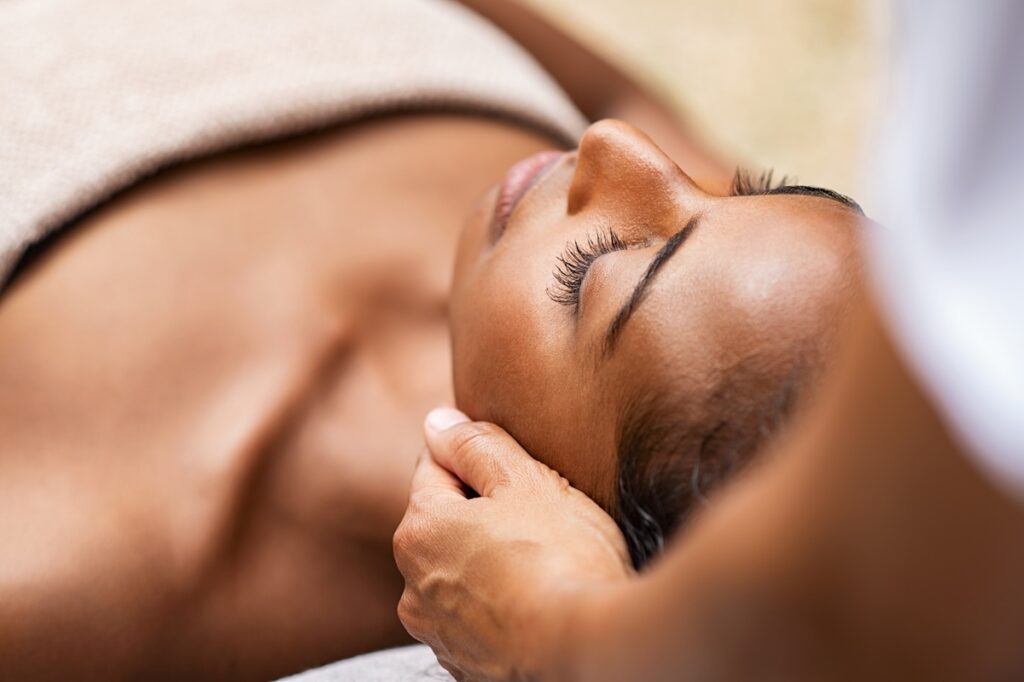 A woman with visibly glowing, smooth skin during a HydraFacial treatment at a med spa in Jericho, Long Island