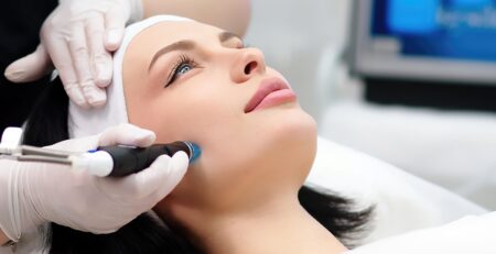 A woman receiving a HydraFacial treatment at a med spa in Jericho, Long Island, with smooth glowing skin