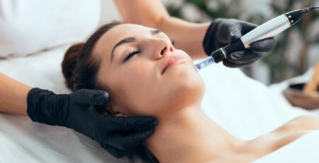 A HydraFacial device being used on a patient at a med spa in Jericho, Long Island, showing the vortex tip on skin